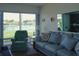 Bright and airy living room with lake views, comfortable seating, and serene atmosphere at 4324 Tahitian Gardens Cir # J, Holiday, FL 34691