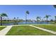 Serene pond view with mature trees, lush green grass, and well-maintained landscaping at 4324 Tahitian Gardens Cir # J, Holiday, FL 34691