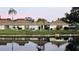 Water view of residential buildings with tropical plants and serene lake reflections at 4324 Tahitian Gardens Cir # J, Holiday, FL 34691