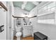 Bathroom featuring a white vanity, a round mirror, and a wood accent on the wall at 4425 W Bay Ave, Tampa, FL 33616