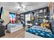 Shared bedroom with two twin beds, decorative wall shelves and a ceiling fan at 4425 W Bay Ave, Tampa, FL 33616