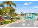 Charming turquoise bungalow featuring lush tropical landscaping and a bright yellow door at 4570 67Th N St, St Petersburg, FL 33709