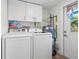Laundry area with white washer and dryer, storage cabinets, and convenient access door at 4570 67Th N St, St Petersburg, FL 33709