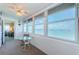 Bright and airy balcony with large windows offering expansive water views and a small table and chair set at 4750 Cove Cir # 1001, St Petersburg, FL 33708