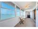 Serene balcony with water views through large windows, complemented by a small table and chair set at 4750 Cove Cir # 1001, St Petersburg, FL 33708