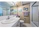 Bright bathroom featuring a white vanity, tile floor, a mirror, and a shower with glass doors at 4750 Cove Cir # 1001, St Petersburg, FL 33708