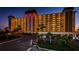 Well-lit condominium building with palm trees and a circular driveway at dusk at 4750 Cove Cir # 1001, St Petersburg, FL 33708