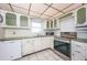 Bright kitchen with stainless steel appliances, tiled countertops and classic white cabinetry at 4750 Cove Cir # 1001, St Petersburg, FL 33708