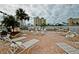 Relaxing poolside area featuring lounge chairs, tables, and lush landscaping at 4750 Cove Cir # 1001, St Petersburg, FL 33708