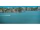 Stunning waterfront scene with luxurious homes, docks, palm trees, and a person enjoying water sports on the bay at 4750 Cove Cir # 1001, St Petersburg, FL 33708