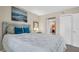 Comfortable bedroom featuring a serene painting, accent pillows, and a doorway leading to a bathroom at 4812 Jasper Dr # 203, New Port Richey, FL 34652