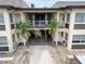 Building exterior with palm trees and open-air walkways to the units at 4812 Jasper Dr # 203, New Port Richey, FL 34652