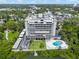 Aerial view of the building and pool and waterfront location surrounded by mature trees at 500 N Osceola Ave # 811, Clearwater, FL 33755