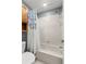 Cozy bathroom featuring a shower, a toilet, and tiled walls with a floral curtain at 5100 Burchette Rd # 2702, Tampa, FL 33647