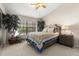 This is a comfortable bedroom with a large window, neutral carpeting, and a ceiling fan at 5100 Burchette Rd # 2702, Tampa, FL 33647
