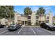 Townhouse exterior featuring neutral paint, a well manicured landscape, and ample parking with mature palm trees at 5100 Burchette Rd # 2702, Tampa, FL 33647