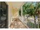 Spacious outdoor balcony surrounded by lush tropical landscaping and an adjacent building at 512 1St St # 108, Indian Rocks Beach, FL 33785
