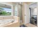 Bathroom with glass-enclosed shower, soaking tub, and an exterior window at 512 1St St # 108, Indian Rocks Beach, FL 33785