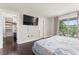 Bedroom with walk-in closet, TV, and balcony access overlooking lush greenery at 512 1St St # 108, Indian Rocks Beach, FL 33785