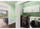 Convenient laundry room with modern washer and dryer, along with overhead cabinetry at 512 1St St # 108, Indian Rocks Beach, FL 33785