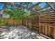 Enclosed gravel backyard with a wooden fence, featuring a custom-built trellis at 526 36Th Ne Ave, St Petersburg, FL 33704