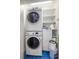 A conveniently stacked washer and dryer setup with organized shelving in the laundry area at 526 36Th Ne Ave, St Petersburg, FL 33704