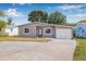 Charming gray single-story home with a well-manicured lawn and a driveway leading to an attached garage at 5326 22Nd N Ave, St Petersburg, FL 33710