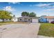 Inviting one-story home with a spacious driveway, manicured lawn, and attached garage, set against a blue sky at 5326 22Nd N Ave, St Petersburg, FL 33710