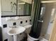 Bathroom featuring a patterned shower, pedestal sink, and black toilet seat at 5600 9Th N Ave, St Petersburg, FL 33710
