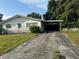 Single-story home with long driveway, covered carport, and well-kept landscaping at 5600 9Th N Ave, St Petersburg, FL 33710