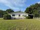Cozy single-story home with a lush, green lawn, mature trees, and a classic carport at 5600 9Th N Ave, St Petersburg, FL 33710
