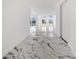 Hallway featuring sleek marble floors and crisp, white walls leading to bright, open living spaces at 600 115Th Ave, Treasure Island, FL 33706