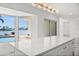 Kitchen island featuring white marble countertops, gold hardware, and a view of the outdoor pool and waterway at 600 115Th Ave, Treasure Island, FL 33706