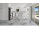 Spacious kitchen featuring a center island, stainless steel appliances, white cabinets, and sliding glass door to patio at 600 115Th Ave, Treasure Island, FL 33706