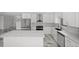Bright kitchen with stainless steel appliances, center island, stylish backsplash, and white marble flooring at 600 115Th Ave, Treasure Island, FL 33706