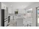 Open kitchen with a center island, stainless steel appliances, white cabinets and marble flooring at 600 115Th Ave, Treasure Island, FL 33706