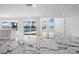 Spacious living area featuring marble floors, a modern design, and waterfront views from multiple windows at 600 115Th Ave, Treasure Island, FL 33706