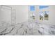 Living room features white walls, modern marble floors, and view of the water at 600 115Th Ave, Treasure Island, FL 33706