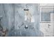 Close-up on the stylish walk-in shower with marble-style blue tile and modern fixtures at 600 115Th Ave, Treasure Island, FL 33706