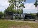 This single-story home features an attached carport and is surrounded by a chain-link fence at 6095 108Th N Ave, Pinellas Park, FL 33782