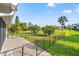 Manicured backyard with lush green lawn, a tall palm tree, and black metal fencing at 629 Fort Duquesna Dr, Sun City Center, FL 33573