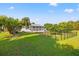 Green backyard with a well-maintained lawn, mature trees, and black metal fencing at 629 Fort Duquesna Dr, Sun City Center, FL 33573