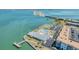 Aerial view showing tennis courts, pool, clubhouse, and waterfront access with a fishing pier at 7 Elgin Pl # 202, Dunedin, FL 34698