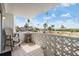 Charming balcony with comfortable seating and scenic views of palm trees and distant waterfront at 7 Elgin Pl # 202, Dunedin, FL 34698