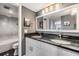 Bathroom features a double vanity with a dark countertop and elegant fixtures, alongside a shower-tub combination at 7 Elgin Pl # 202, Dunedin, FL 34698