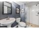 Stylish bathroom with a glass-enclosed shower, pedestal sink, modern fixtures and framed art at 7 Elgin Pl # 202, Dunedin, FL 34698