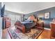 Charming bedroom with a wooden bed frame, an area rug, and a sunlit window with neighborhood views at 7 Elgin Pl # 202, Dunedin, FL 34698