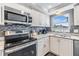 Stylish kitchen featuring stainless steel appliances, granite countertops, and modern fixtures at 7 Elgin Pl # 202, Dunedin, FL 34698