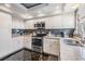 Modern kitchen with stainless steel appliances, granite countertops, and updated backsplash at 7 Elgin Pl # 202, Dunedin, FL 34698