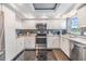 Well-lit kitchen featuring white cabinets, black splash-back and granite countertops with stainless steel appliances at 7 Elgin Pl # 202, Dunedin, FL 34698